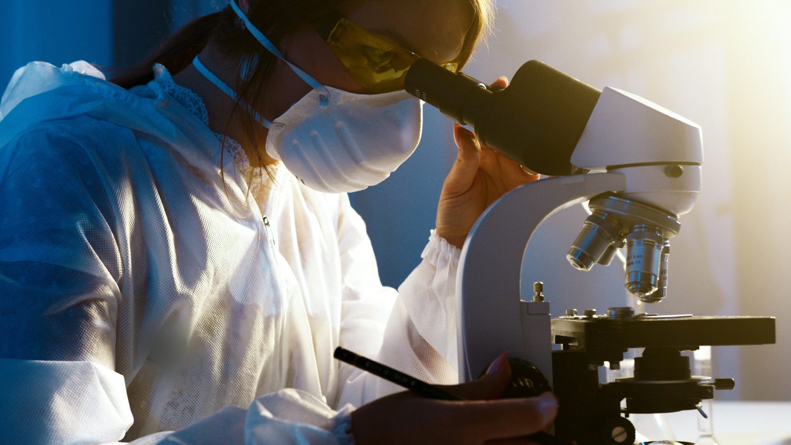 A female scientist uses a microscope in a laboratory, focusing intently on her research.
